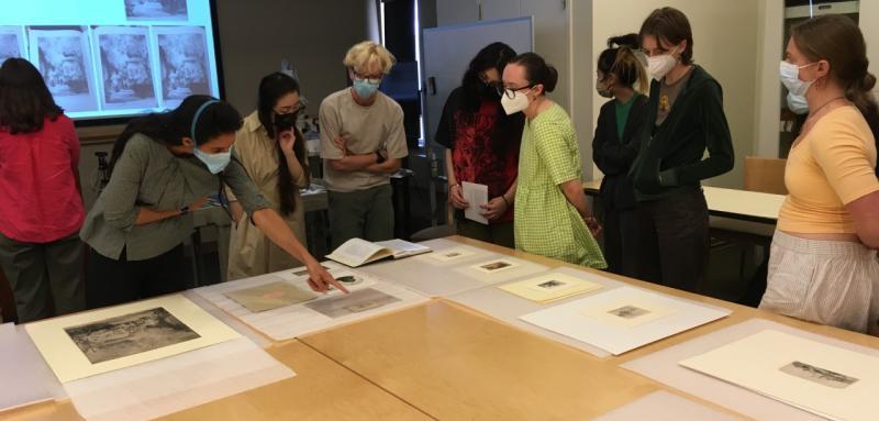 A group of students looking at art on a table